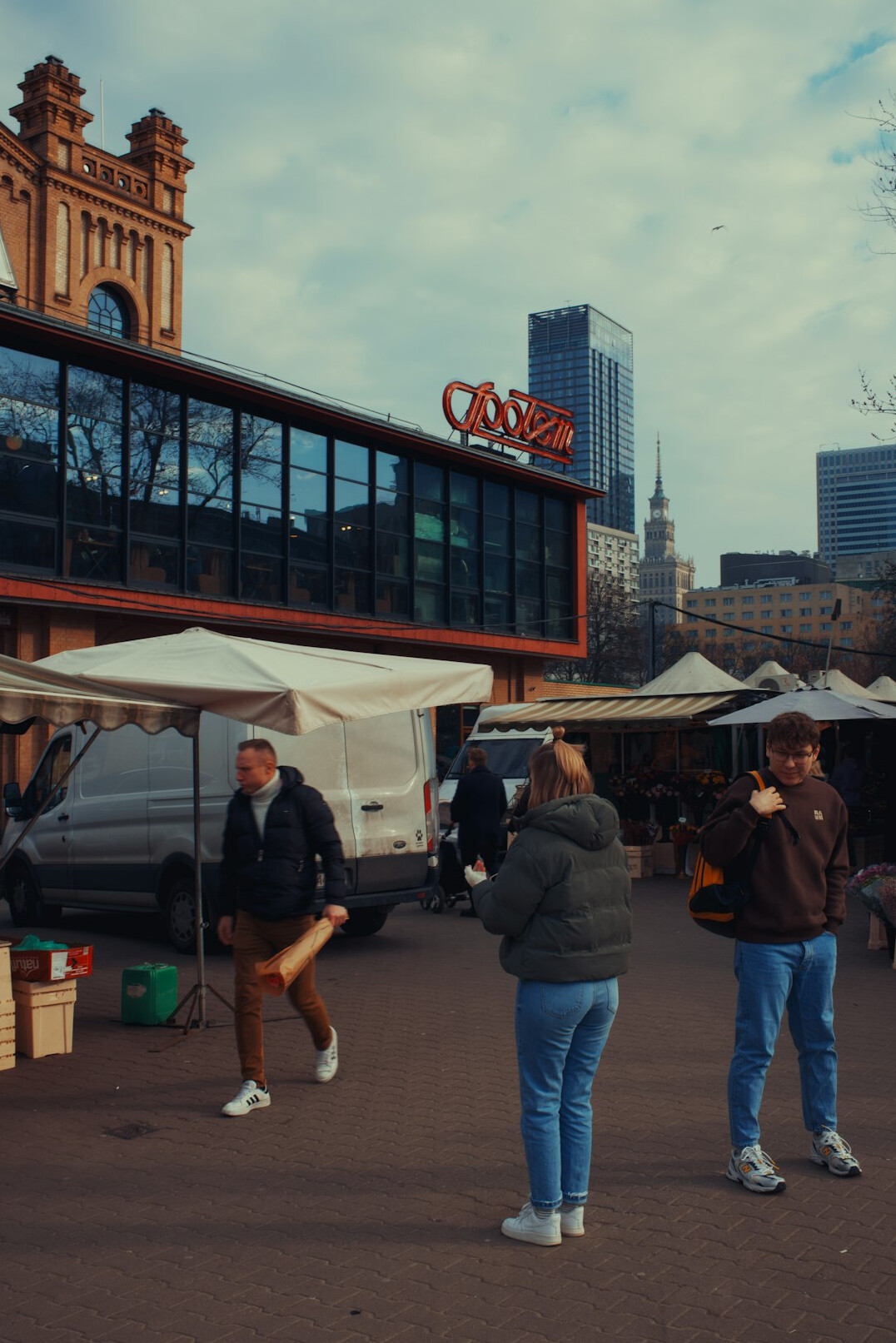 Busy outdoor market scene with vendors and shoppers in Poland