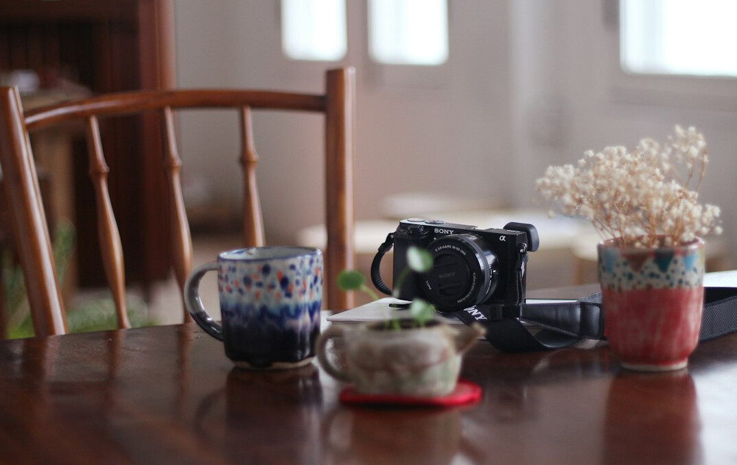 Photographer's desk with camera, prints and coffee cup
