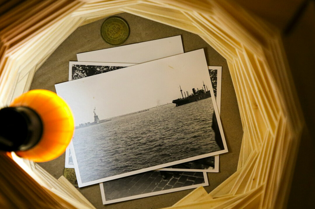 Printed photographs and contact sheets with a magnifying glass on a table