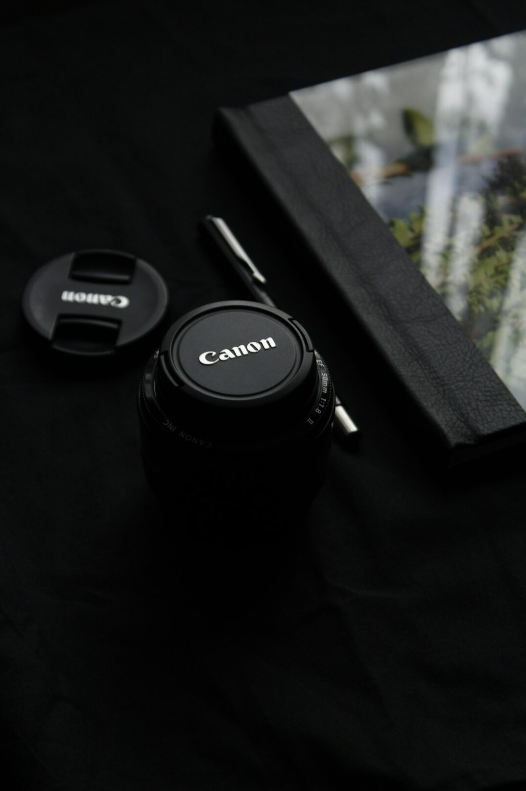 Camera and notebook flat lay on a wooden desk